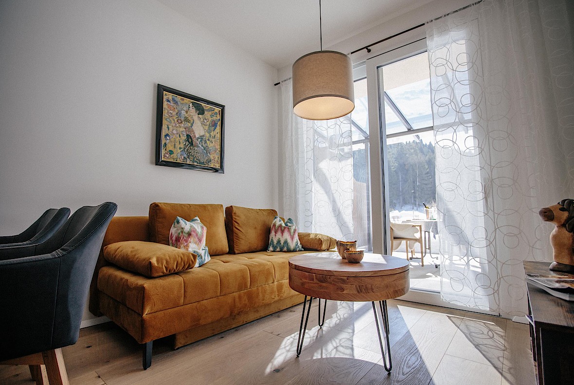 Modernes Wohnzimmer im Appartement Forellenhof Leutasch mit ausziehbarer Couch